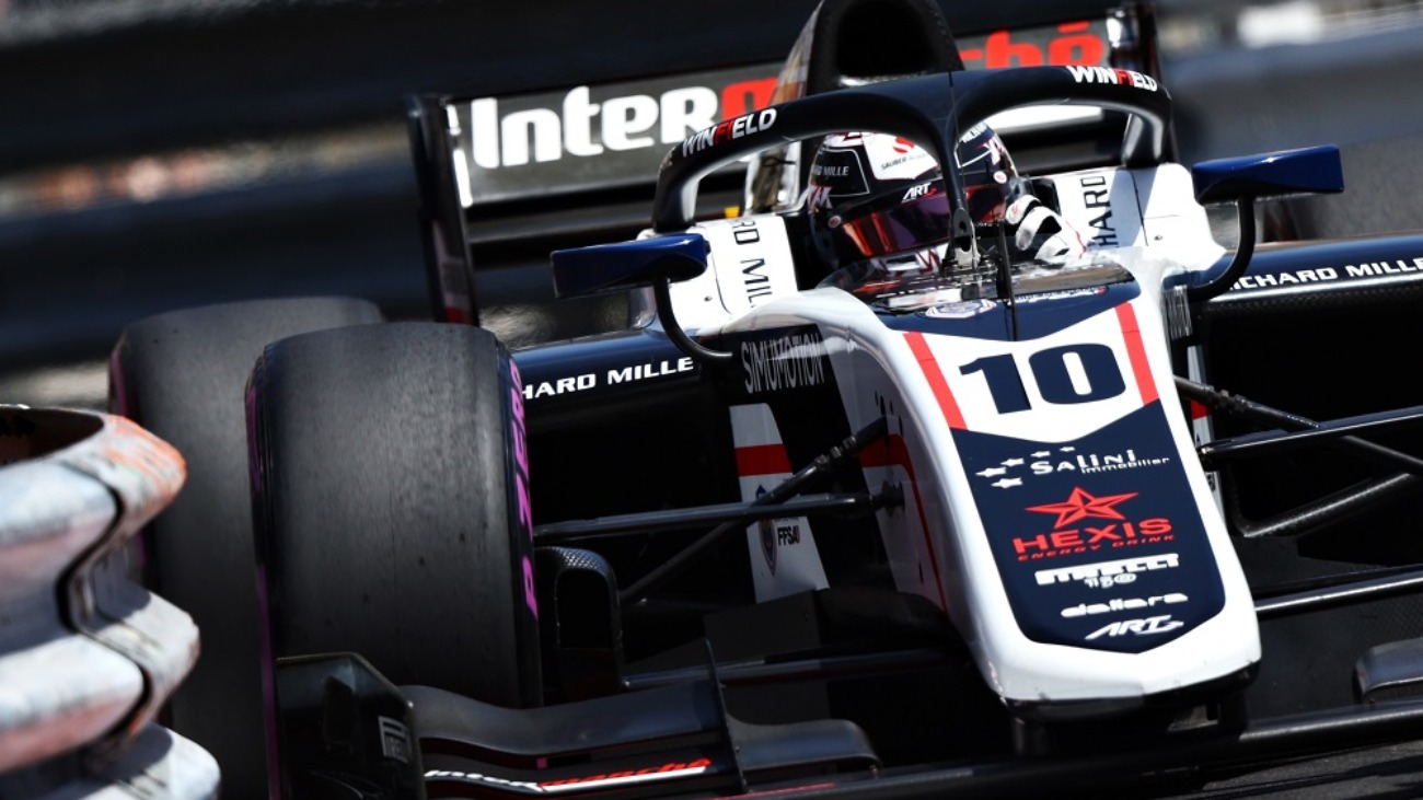 A white and black car turns right, with the right front tyre approaching the barrier on the inside