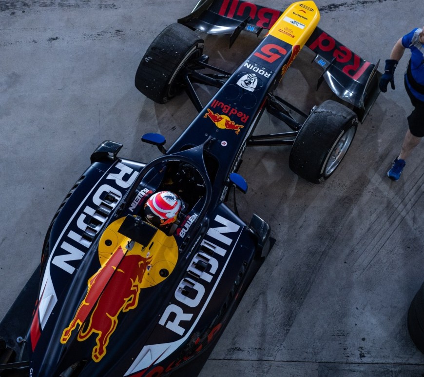 Top-down view of dark blue car with Rodin and Red Bull sponsorships on it.