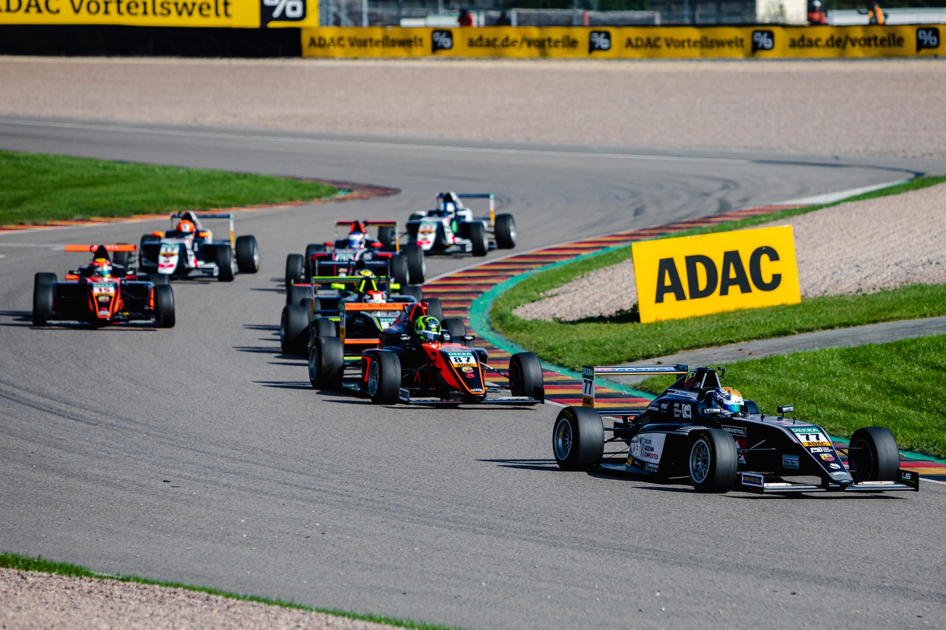 Cars turn left through the sweeping left-hander at Turn 2 of the Sachsenring