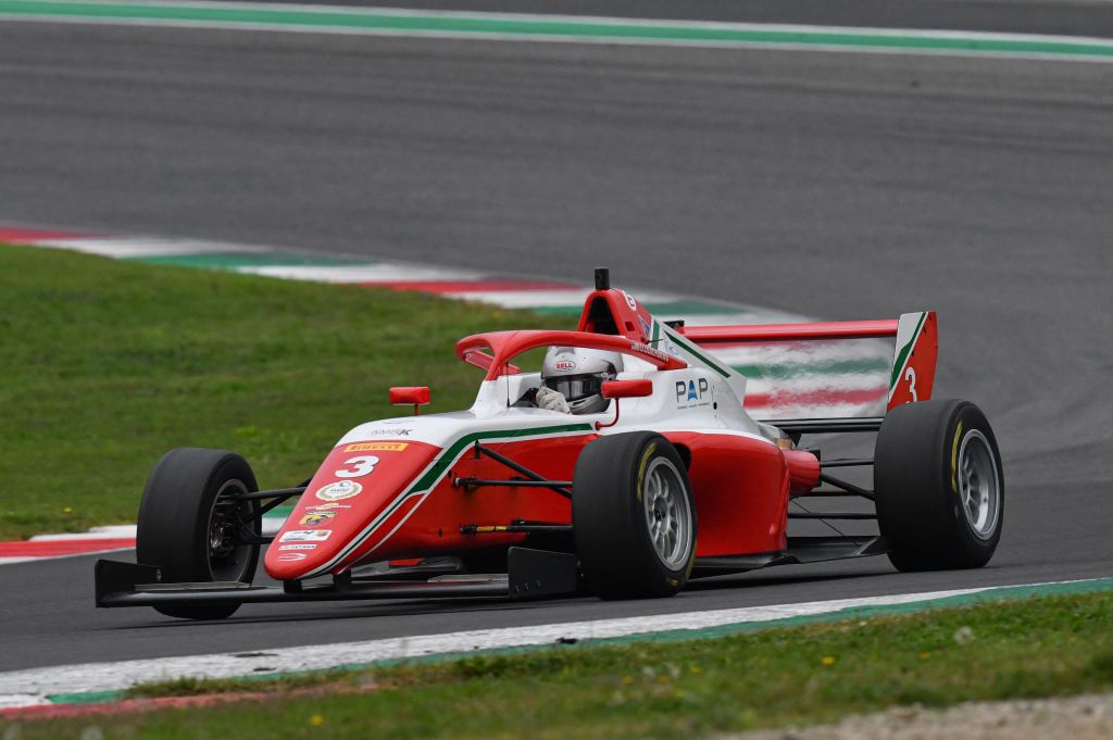 A red and white Italian F4 car on track