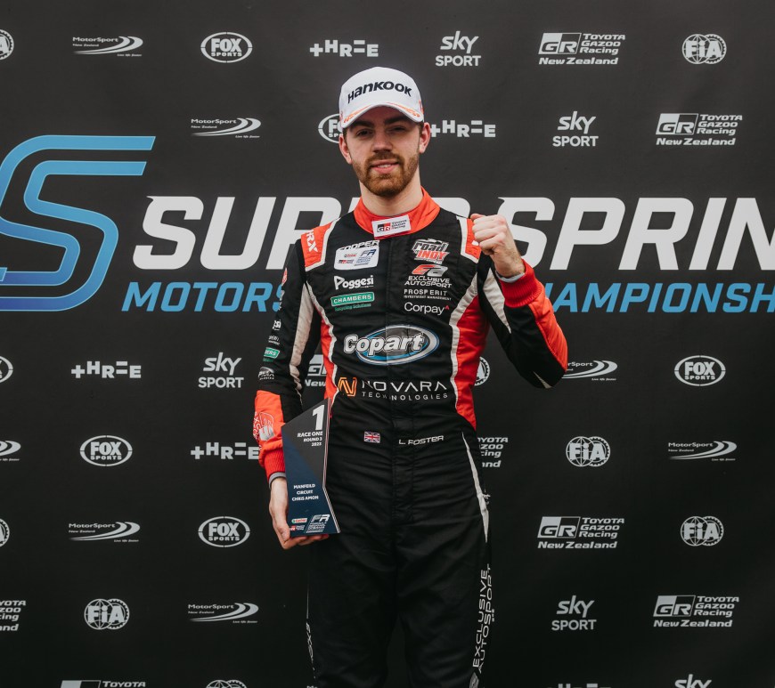 Louis Foster pumps his left fist while holding a first-place trophy in his right hand