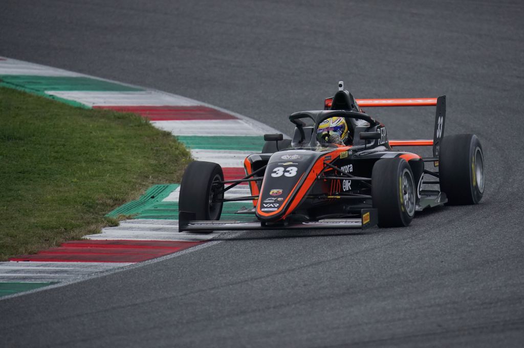 An orange and black talian F4 car on track