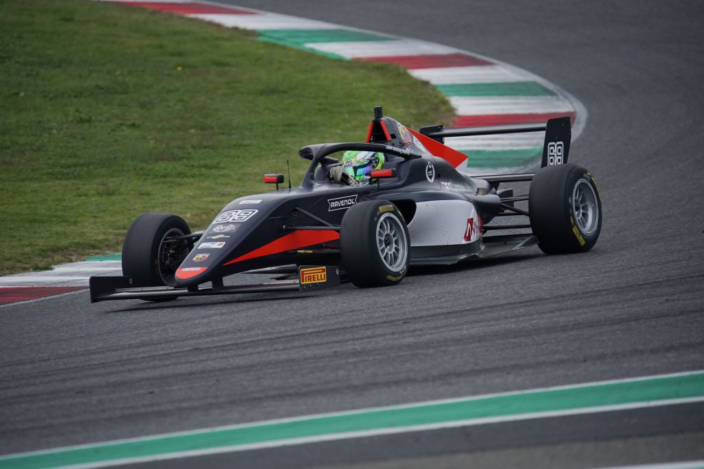 A black and white Italian F4 car on track