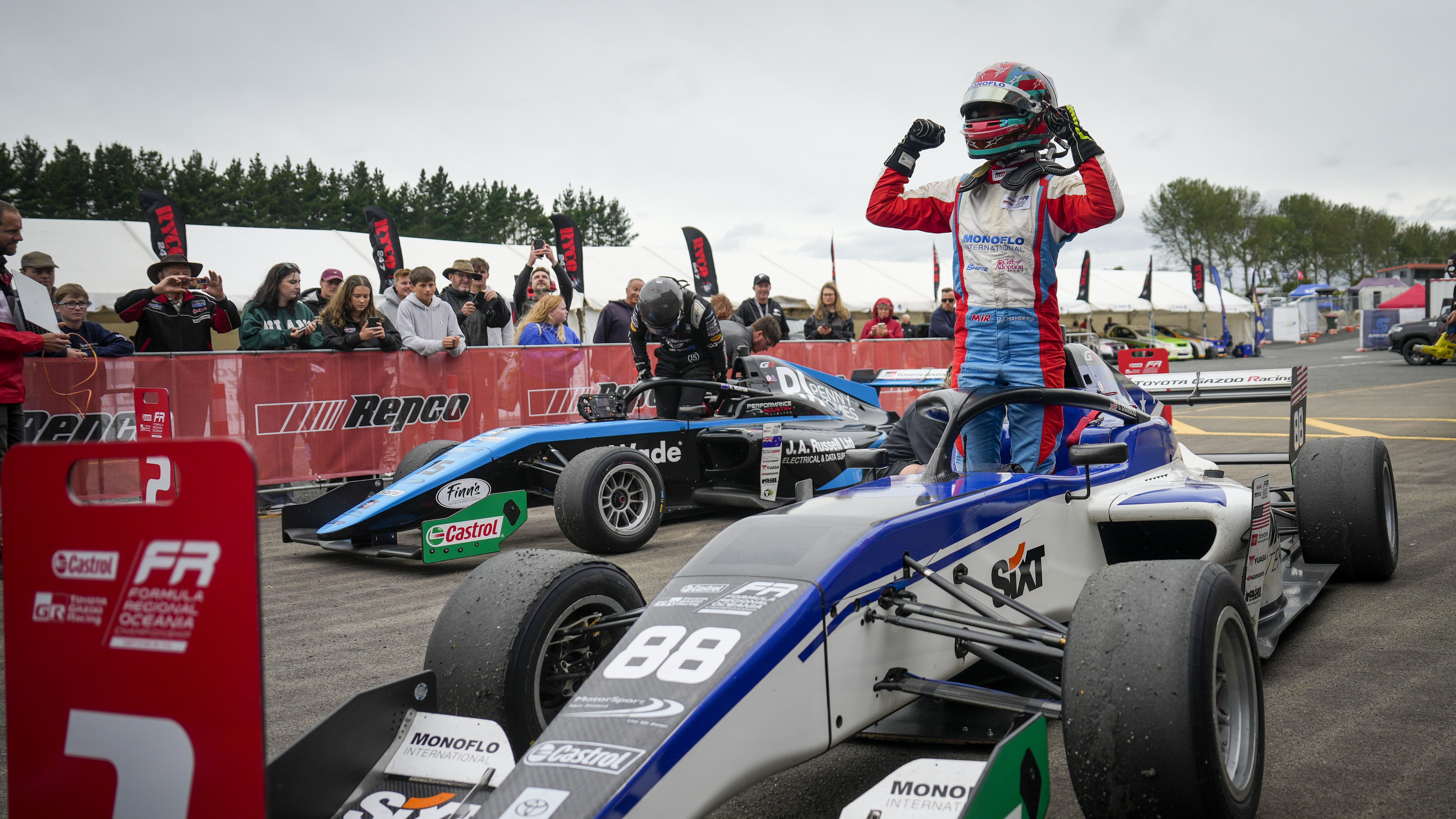 Chloe Chambers standing on her car celebrating her Race 2 win in FROC