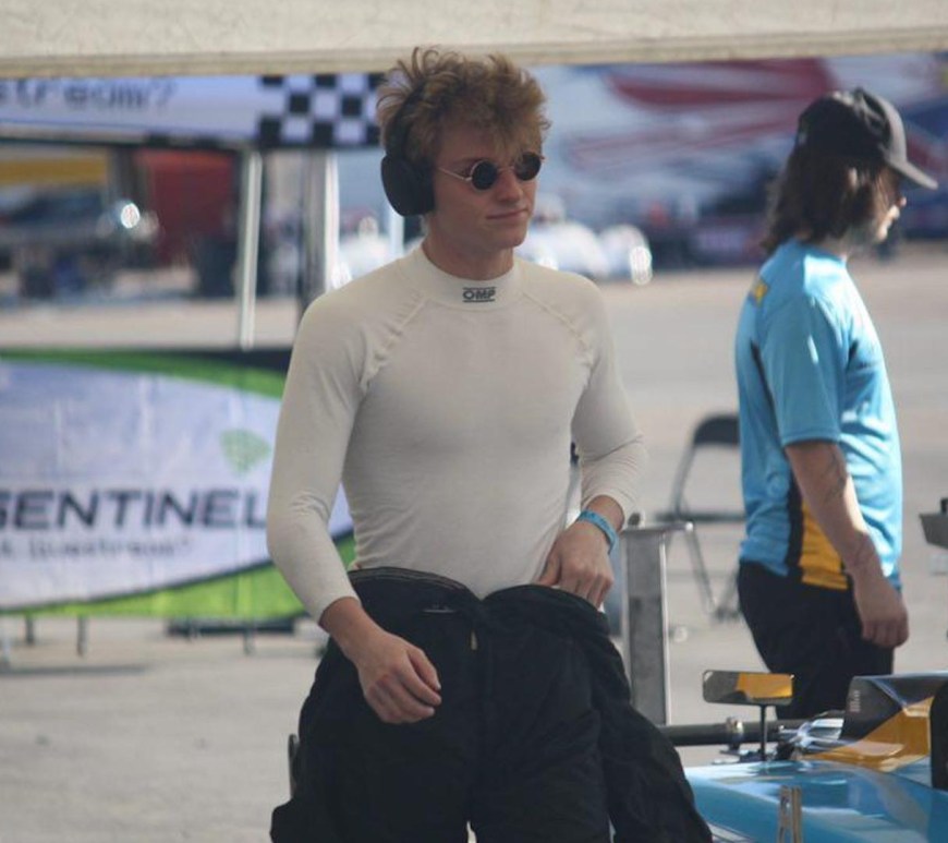 Garrett Dettman walking down pit road wearing headphones and sunglasses