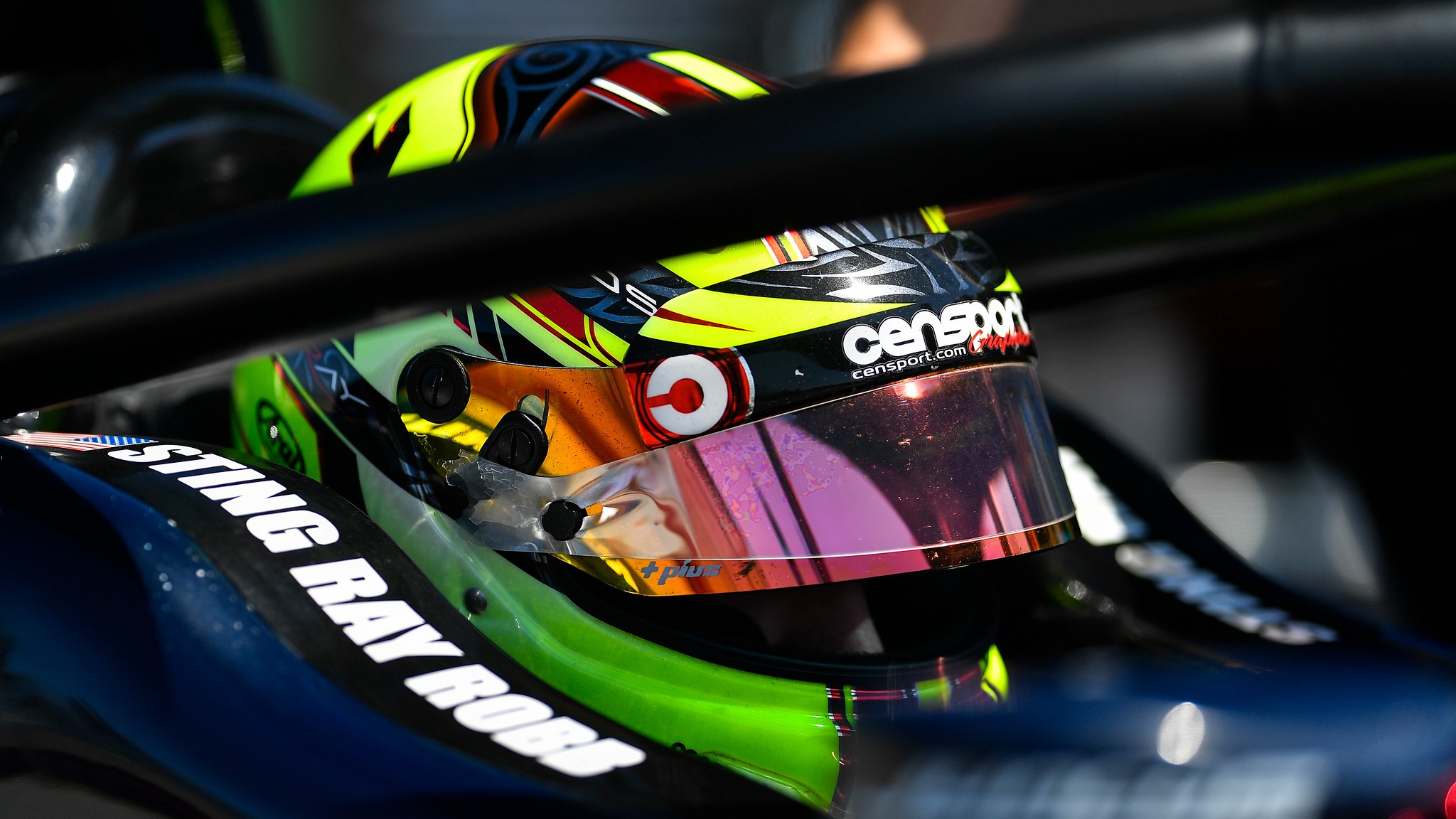 Close-up of Sting Ray Robb sat in the car wearing his racing helmet