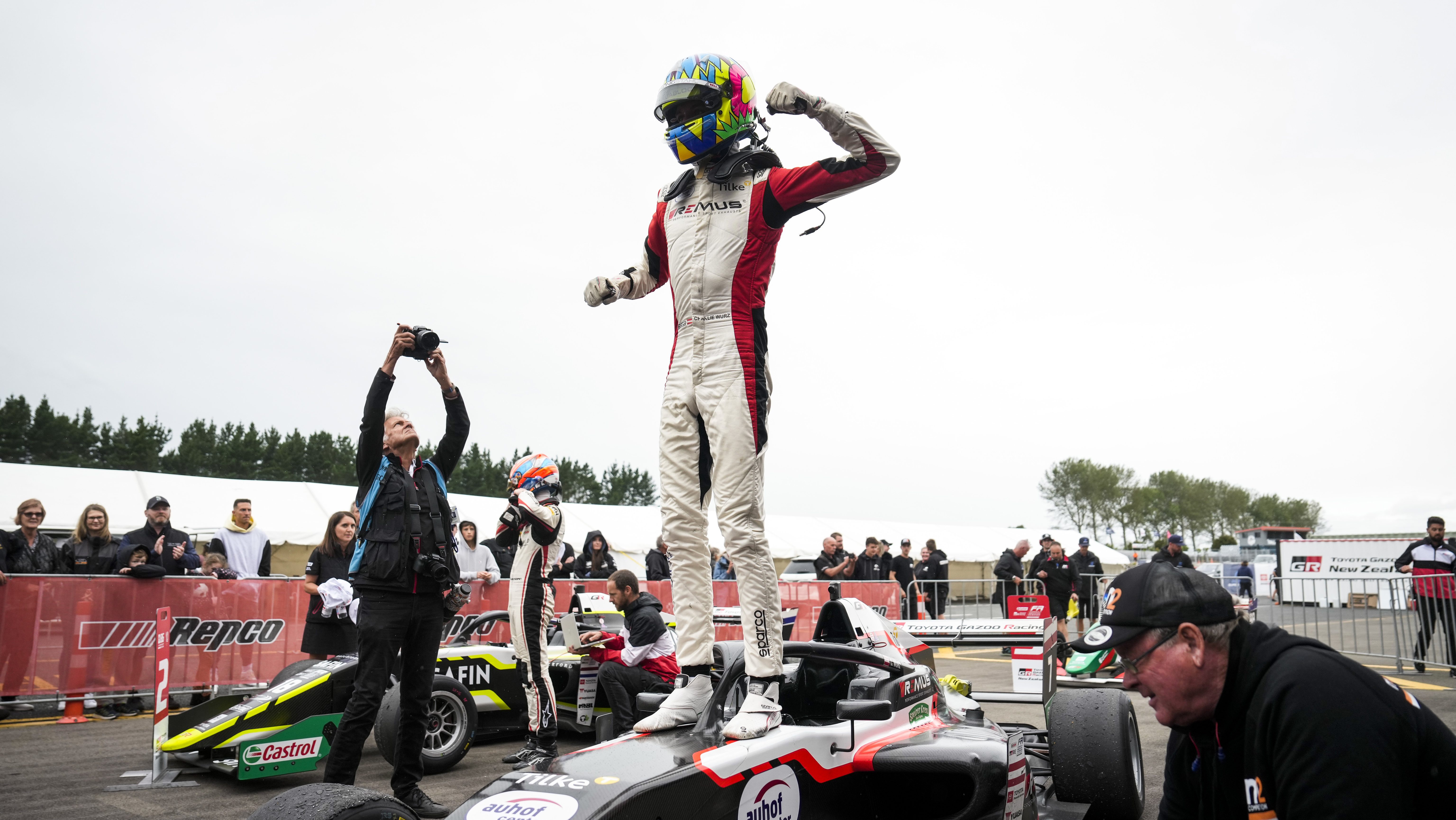 Charlie Wurz standing on top of his car celebrating his championship win