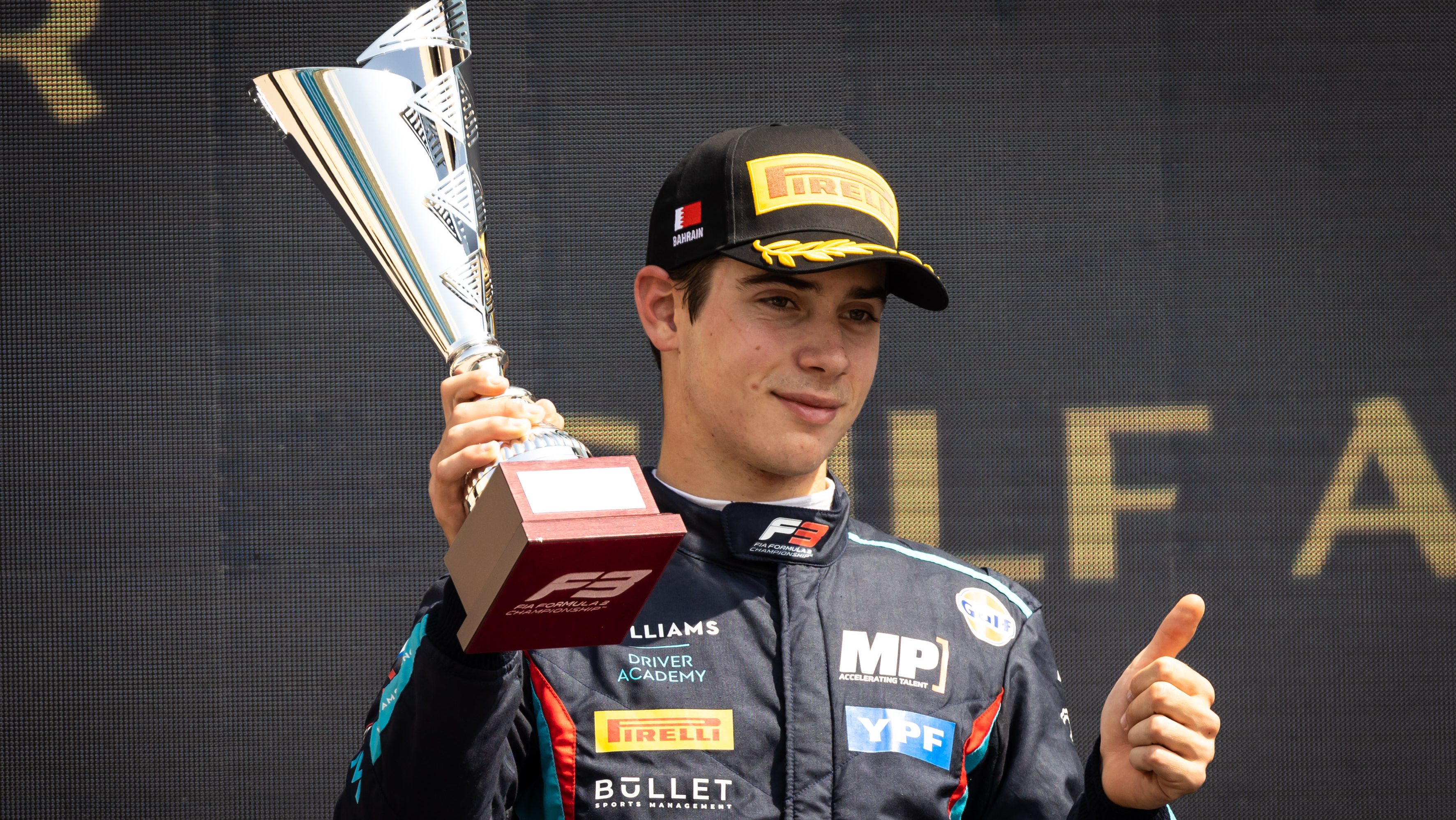 Franco Colapinto holding trophy while doing a thumbs up sign