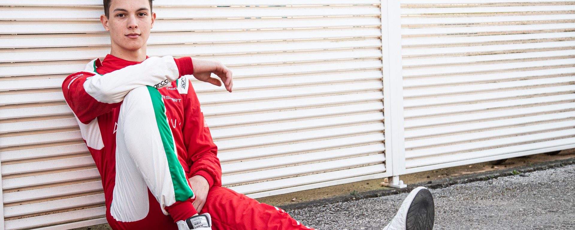 Ollie Bearman sitting against a fence