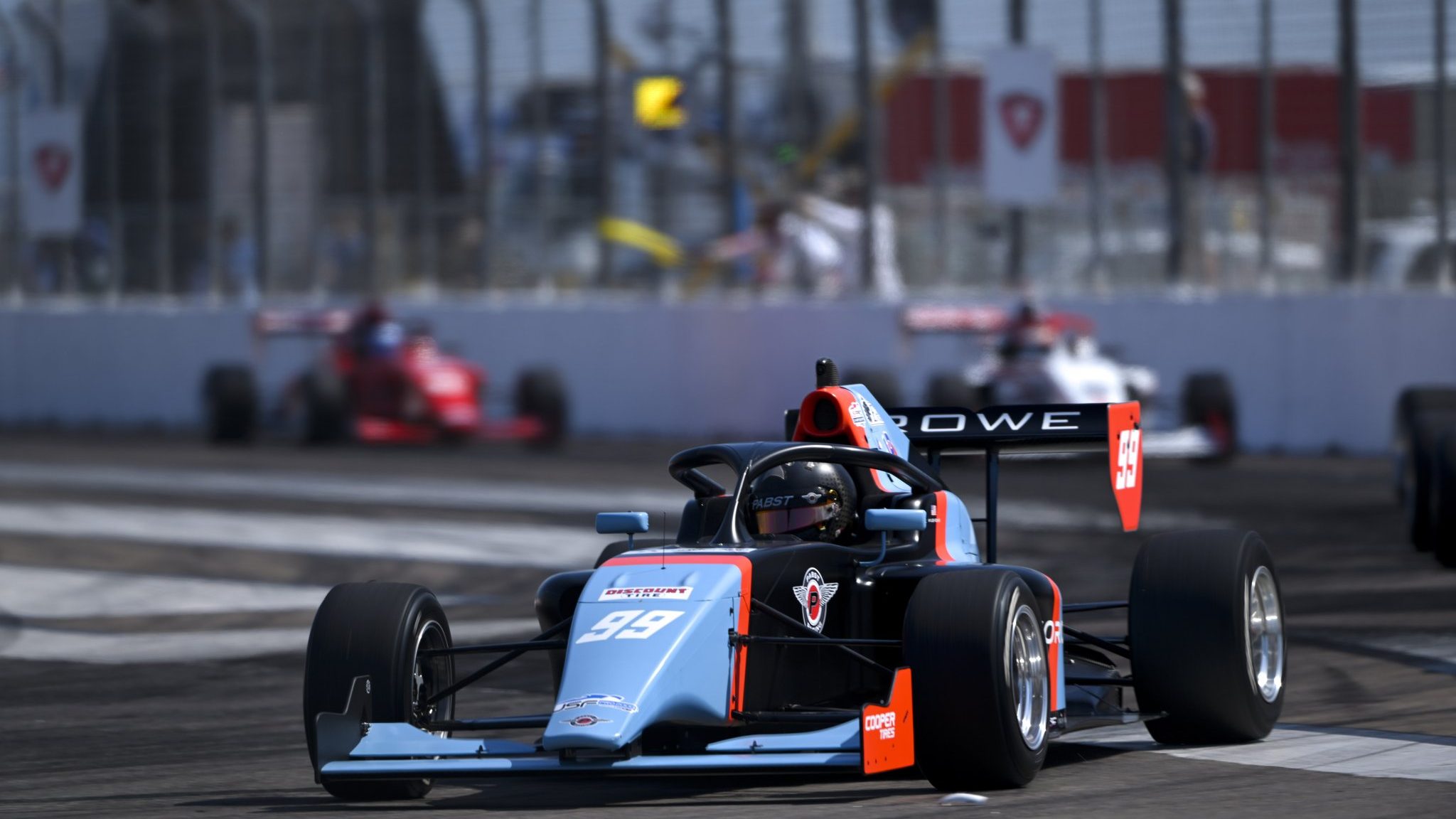 Black, orange and blue car on track