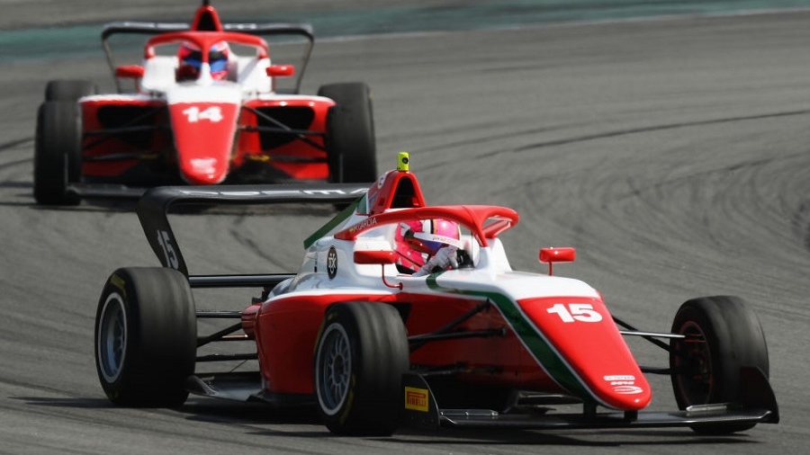 Two red and white F4 cars turning left