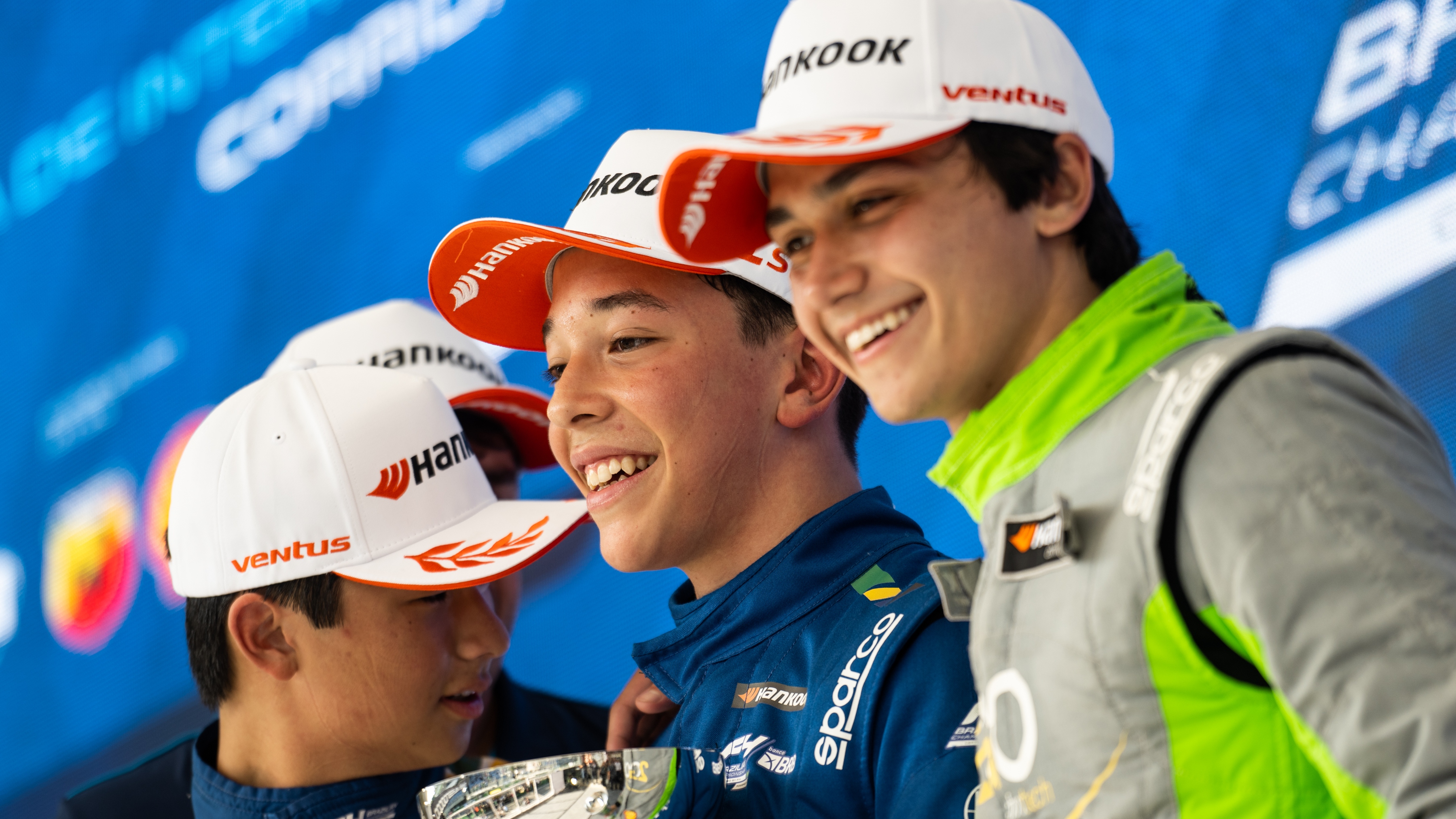 Three drivers in Hankook caps on the podium