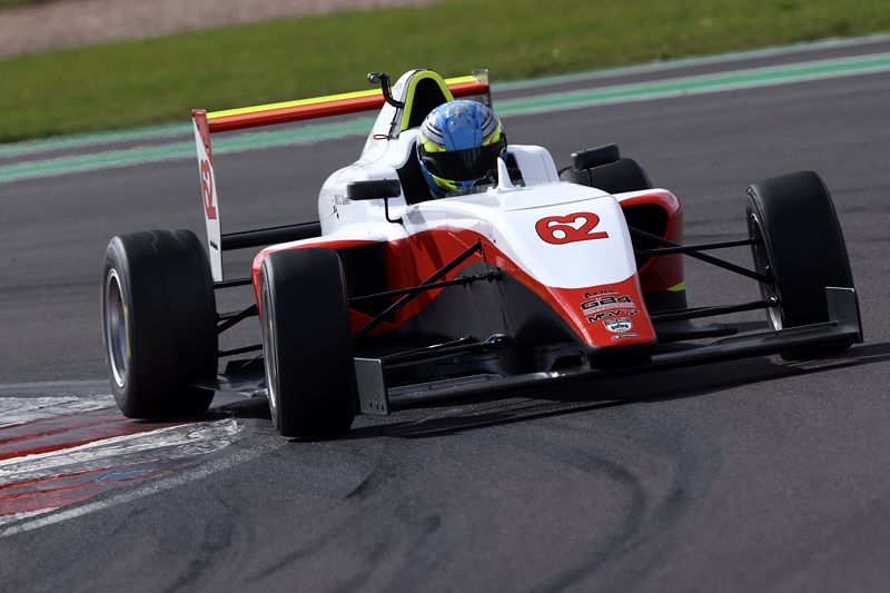 A red and white car on track photographed from the front