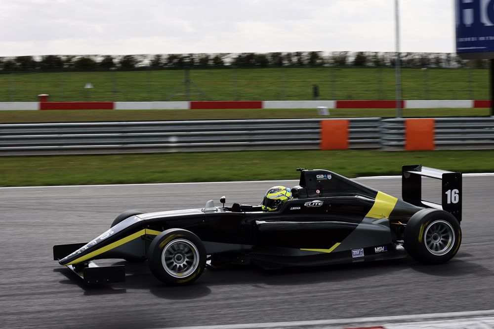 A black and grey car on track photographed from the left