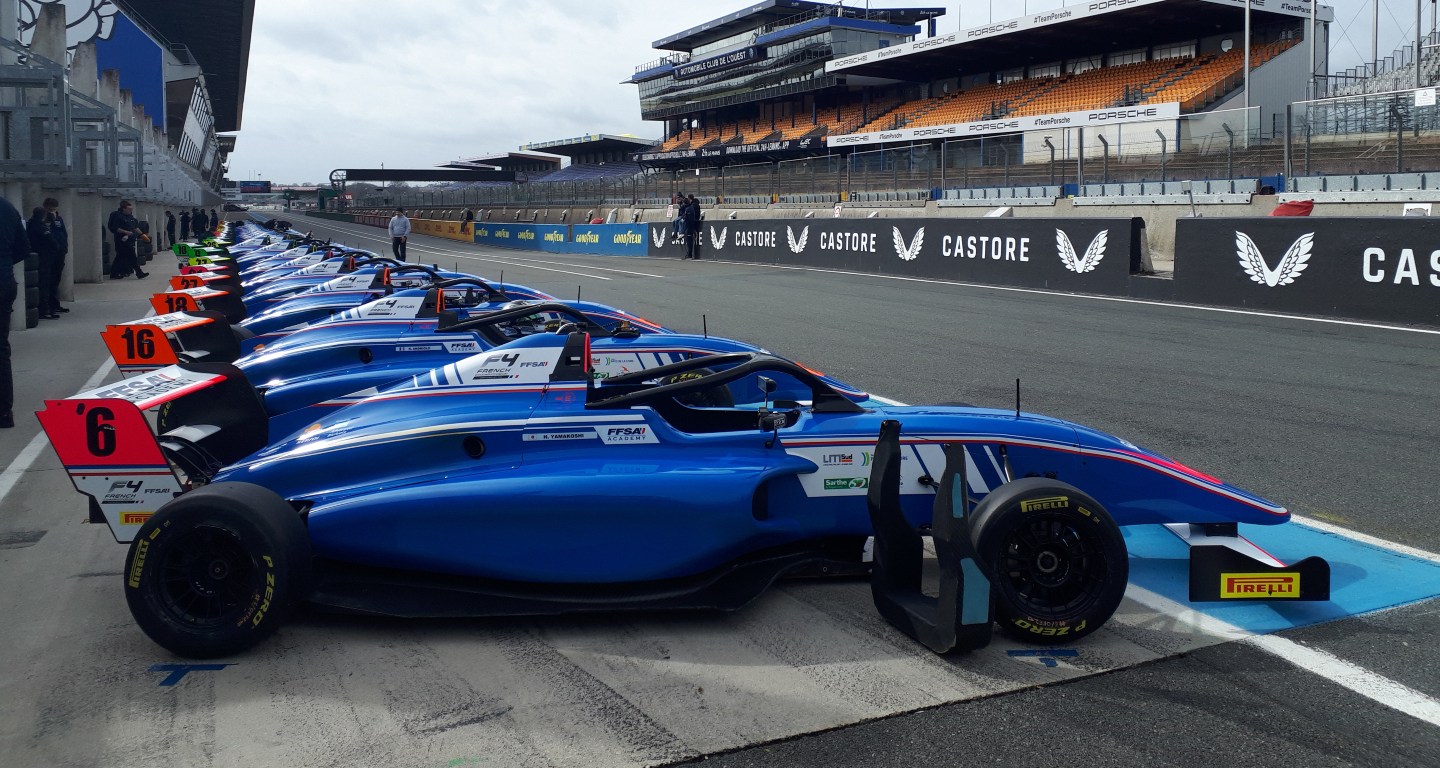 French F4 cars lined up on pit lane at Le Mans, facing to the right