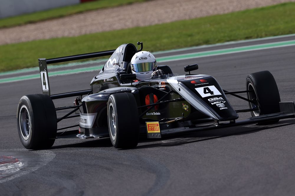 A black car on track photographed from the front right