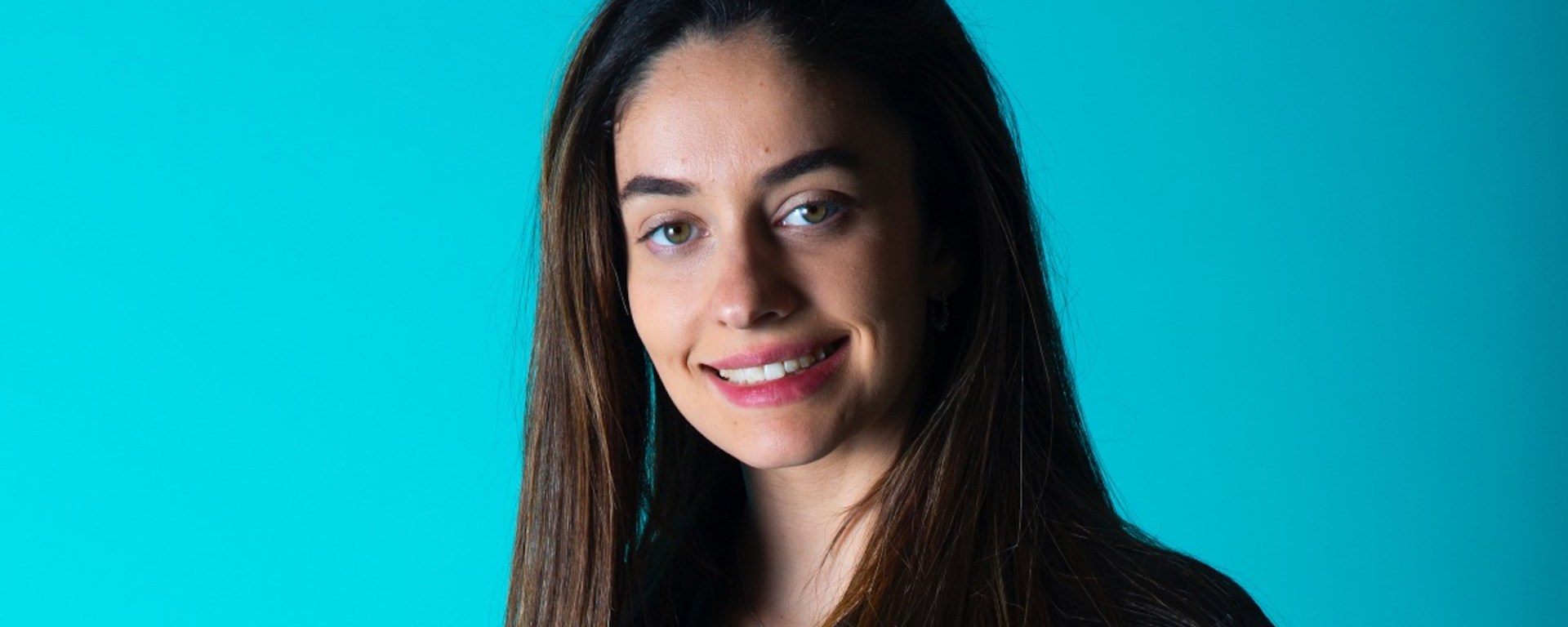 Marta García smiles at the camera against a blue background