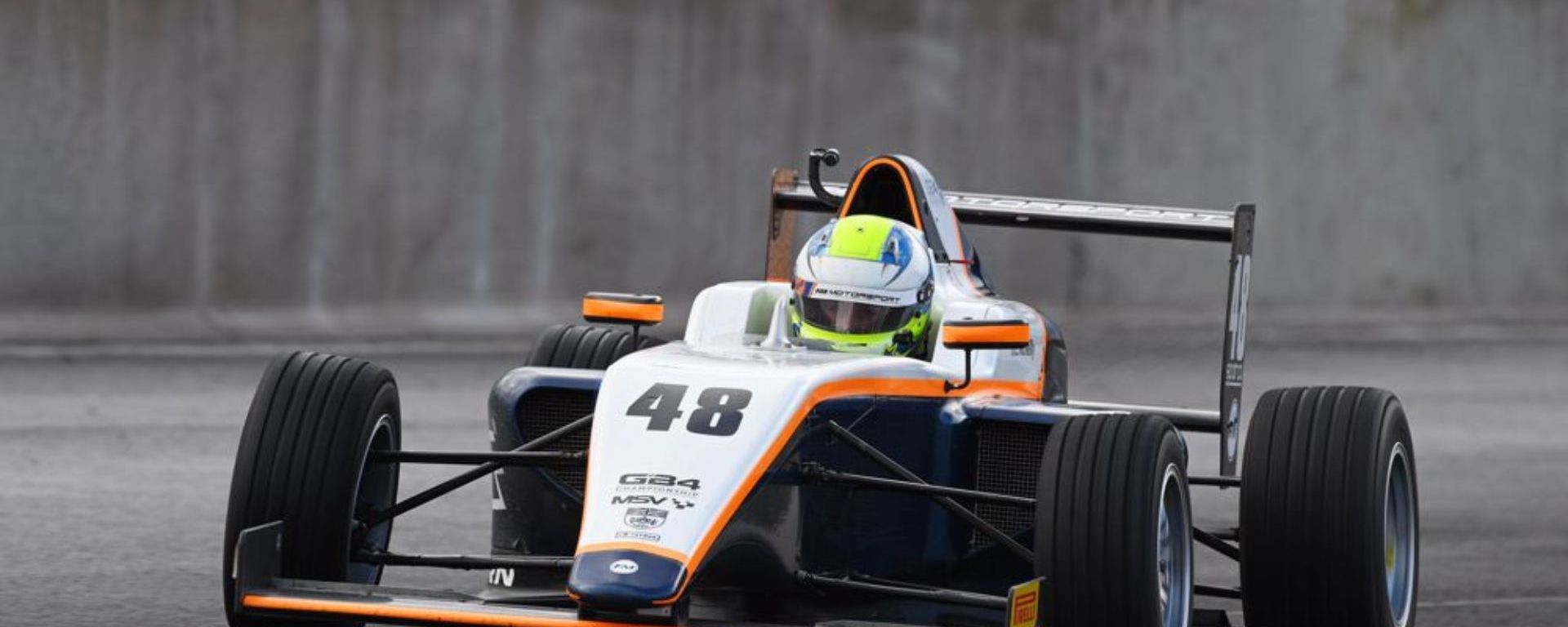A silver, orange and black car in the rain