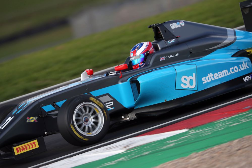 A blue and navy car on track photographed from the left
