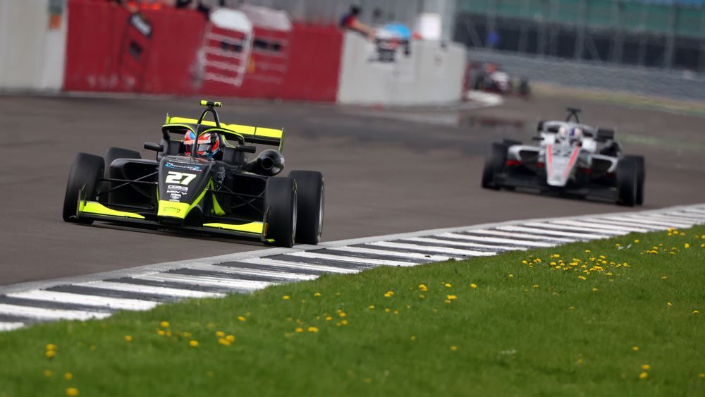A black and neon green car with a silver car in the background
