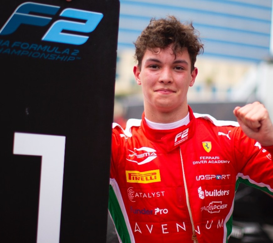 Ollie Bearman holding a P1 sign and pumping his fist, shot from the front