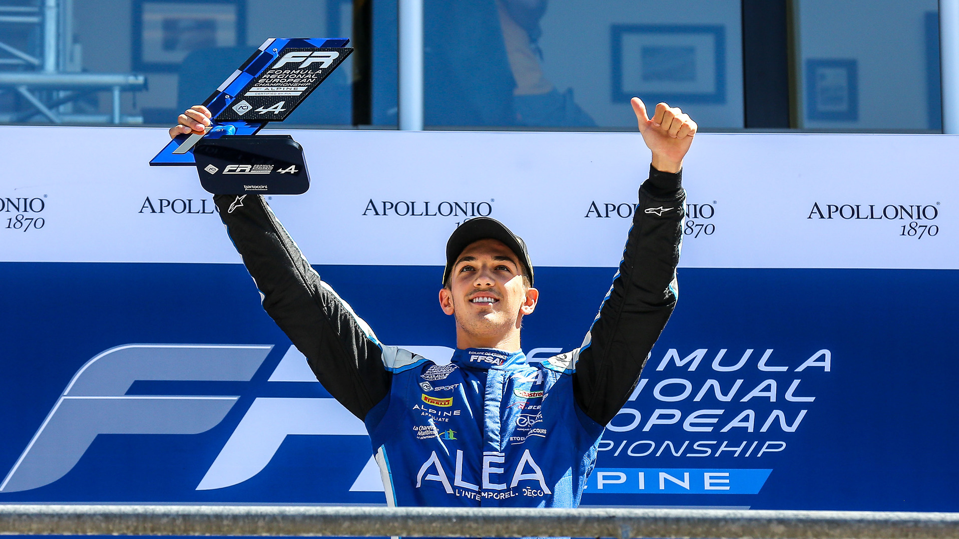 Hadrien David holding up a trophy and giving a thumbs-up
