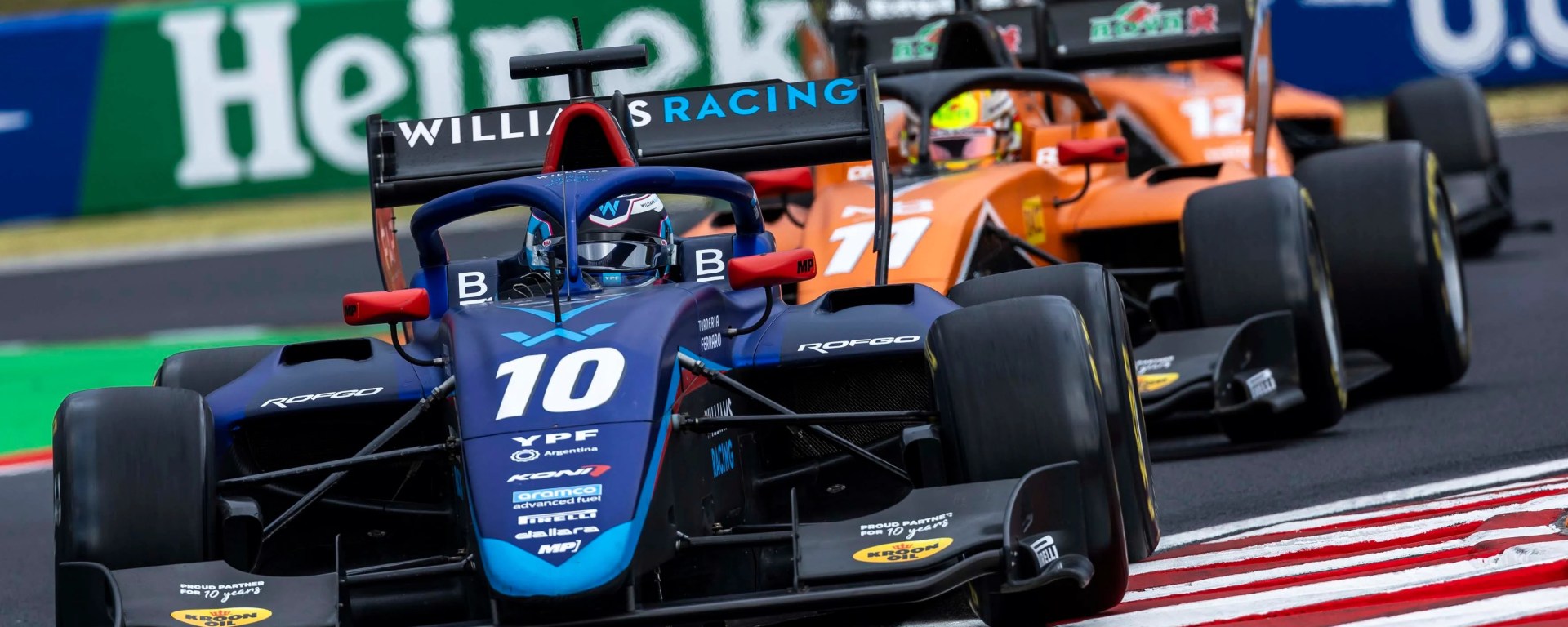 A blue car followed by an orange car