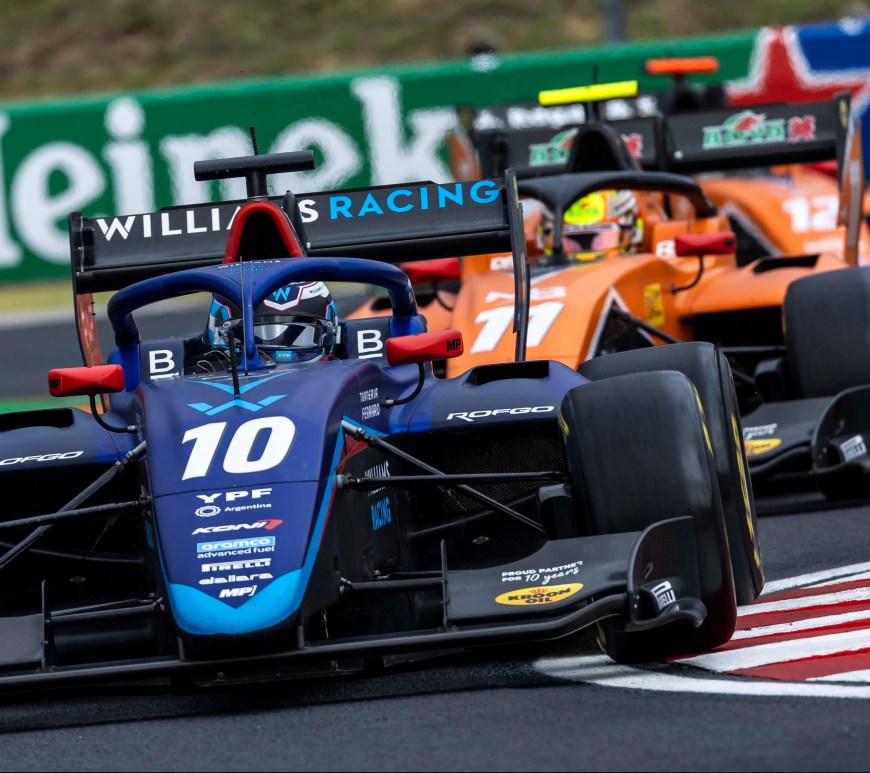 A blue car followed by an orange car