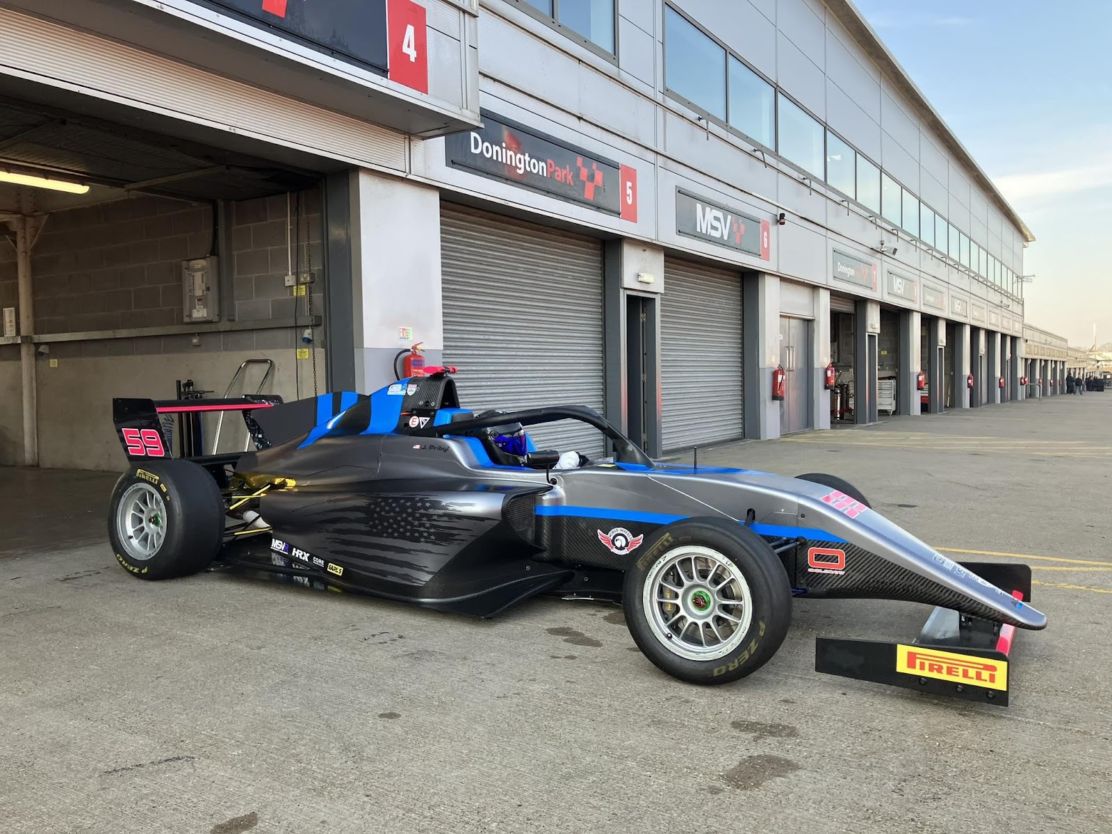 A race car parked in front of a garage

AI-generated content may be incorrect.